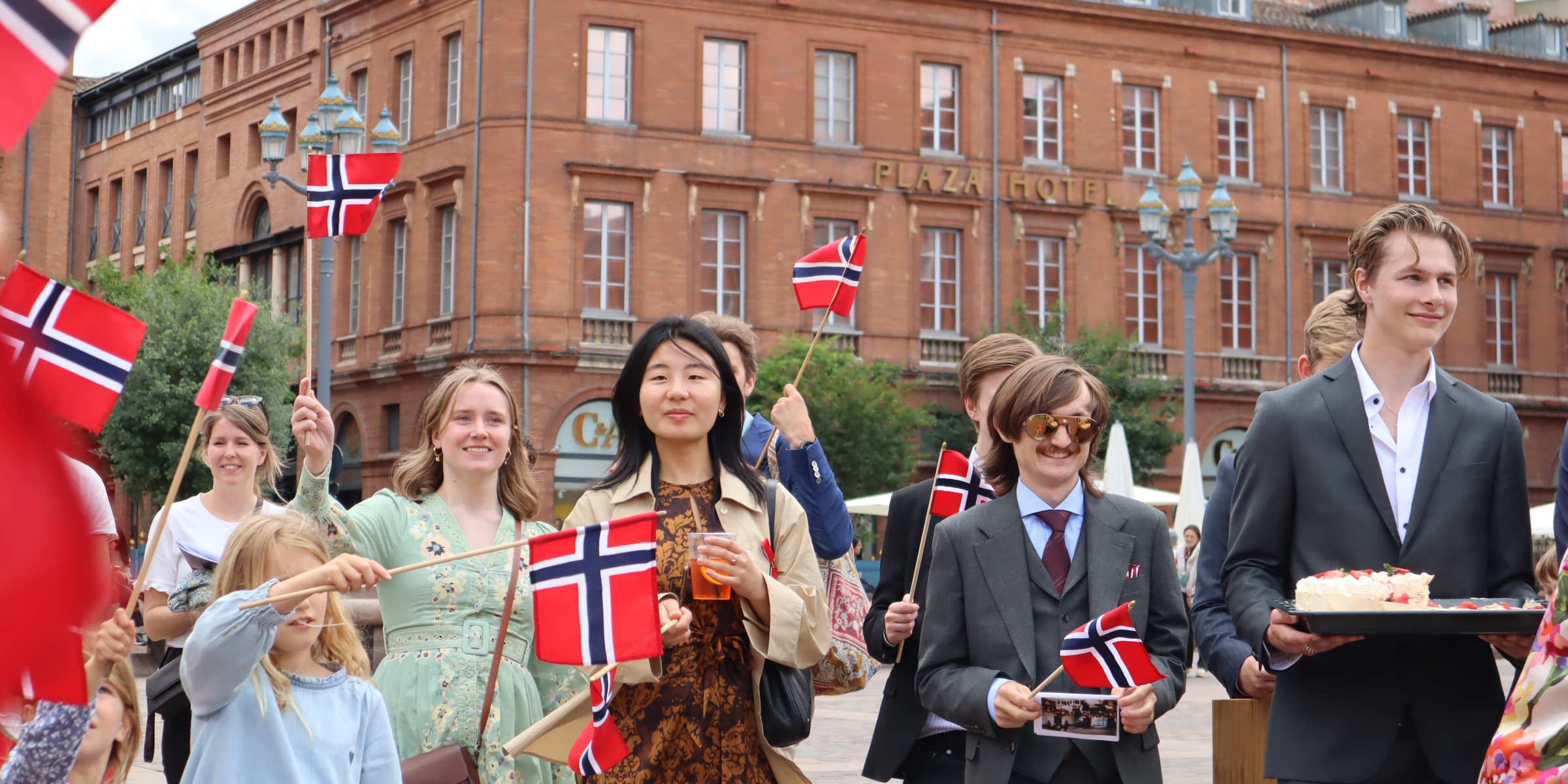 Norske studenter i finstasen med flagg på 17. mai i Toulouse